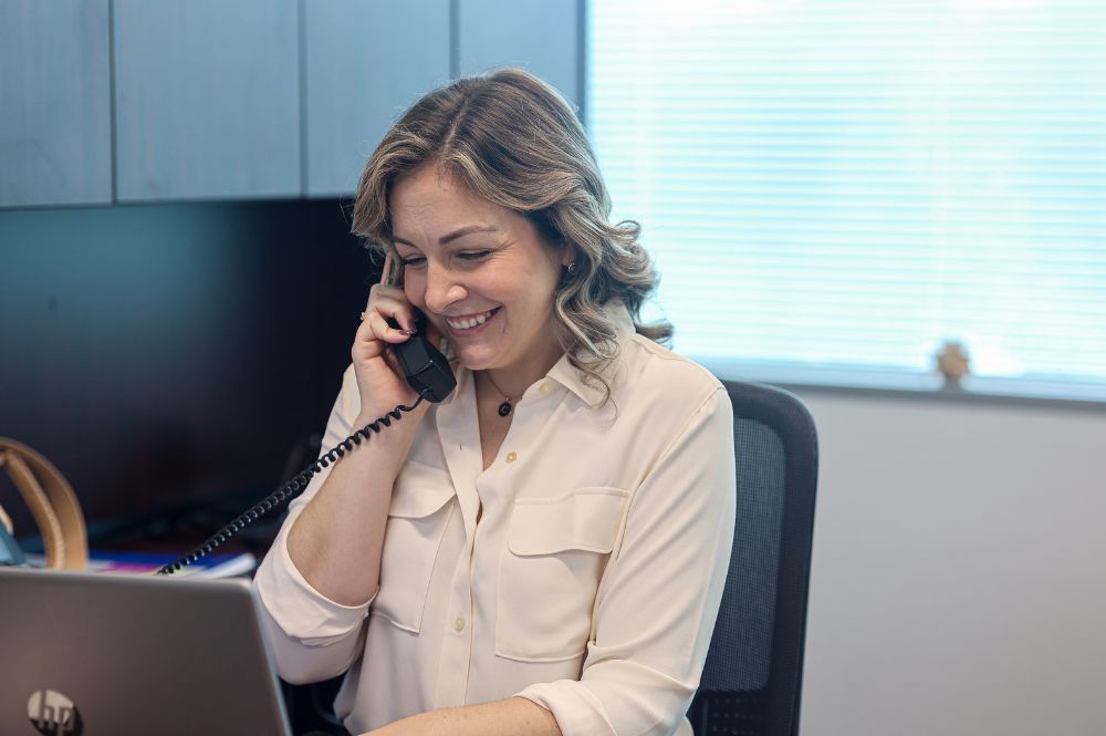 A woman on the phone providing patient support as part of Biopharma PSP services.